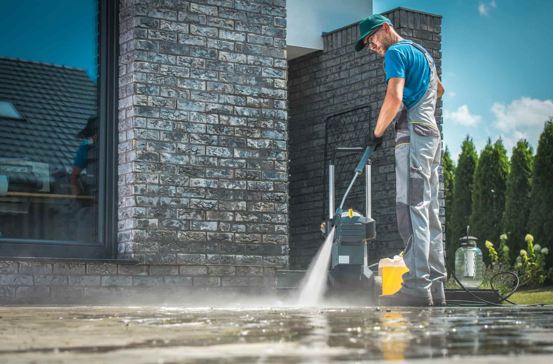 Man pressure washing concrete